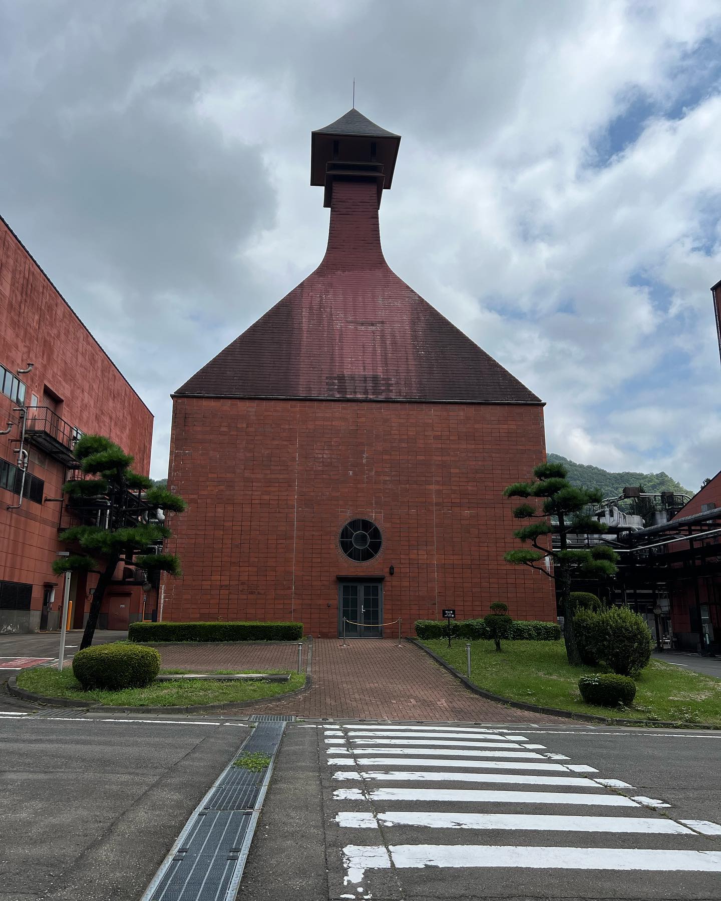 すり鉢状の大屋根が特徴的な赤茶色の煉瓦造りの建物。