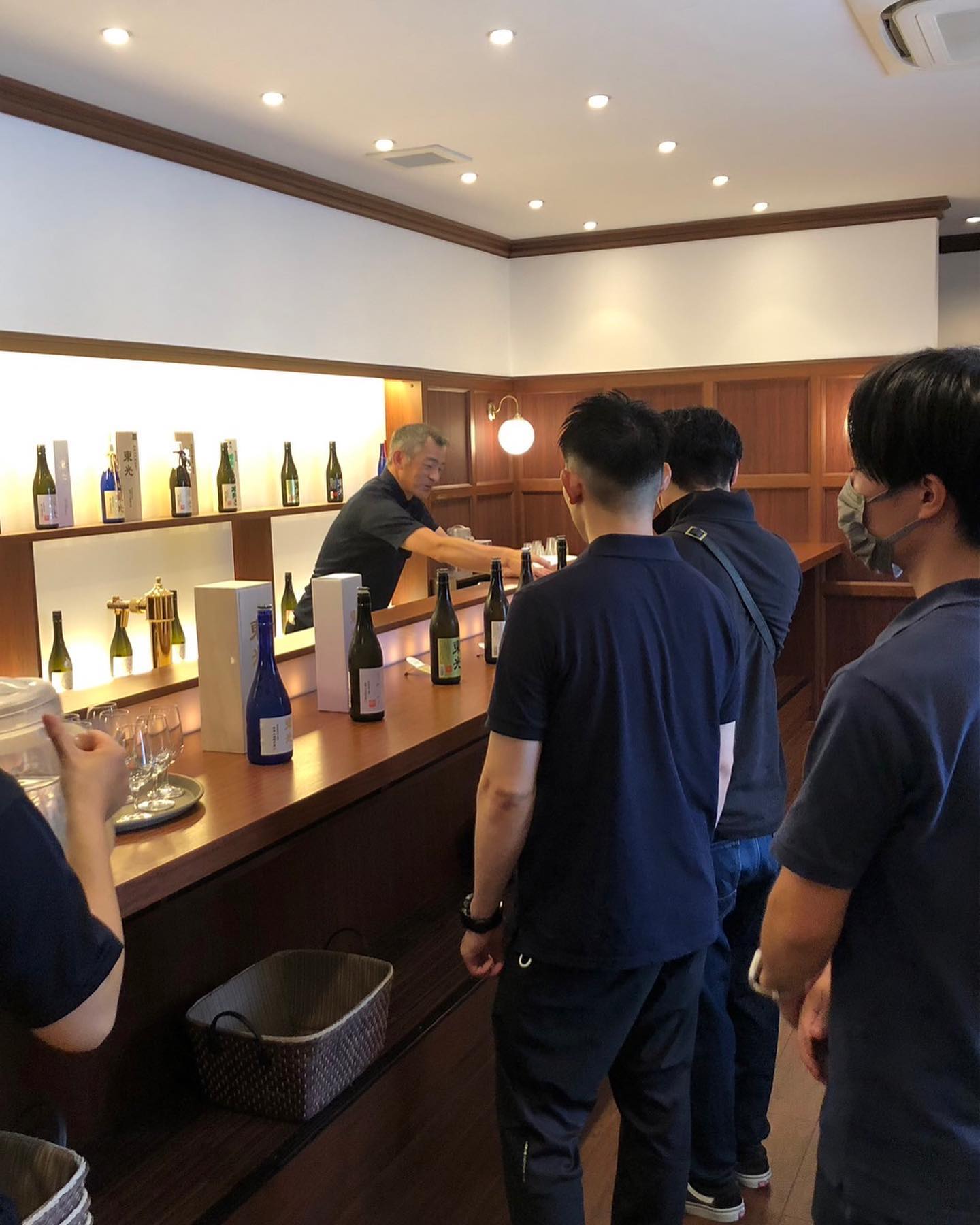 木のカウンターと酒瓶の並ぶ棚の店内。